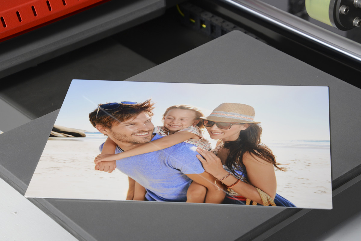 Fertig bedrucktes WunderBoard mit glänzendem, farbintensivem Familienfoto am Strand kühlt auf der Basisplatte der Transferpresse ab