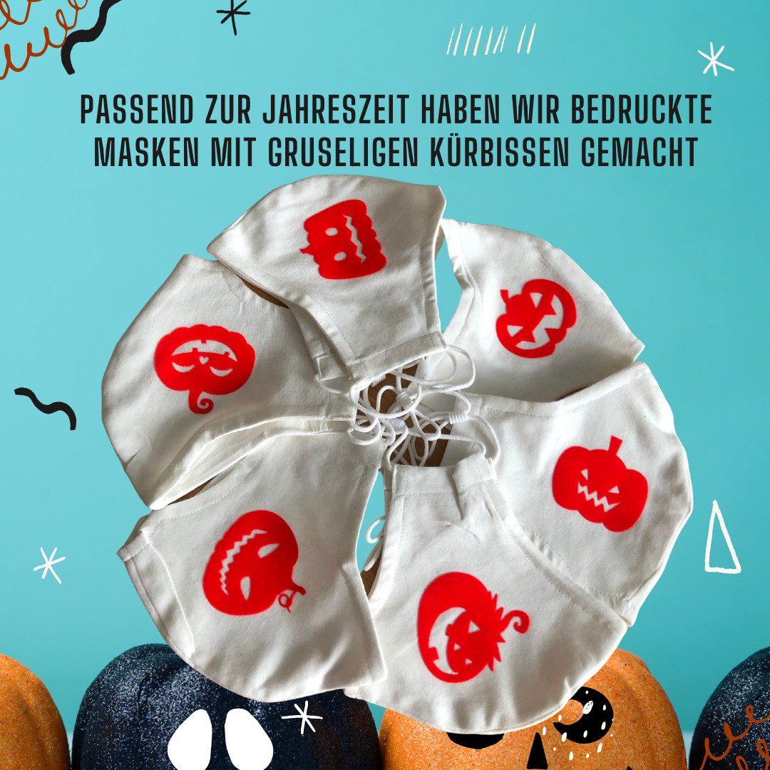 Sechs weiße Stoffmasken mit roten Kürbisgesichtern aus Transferfolie, im Kreis angeordnet vor türkisem Hintergrund mit Halloween-Kürbissen