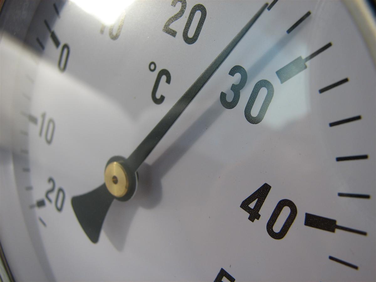 Nahaufnahme eines analogen Thermometers mit Celsius-Skala, Zeiger zwischen 20 und 30 °C, als Symbolbild für Transfertemperaturen