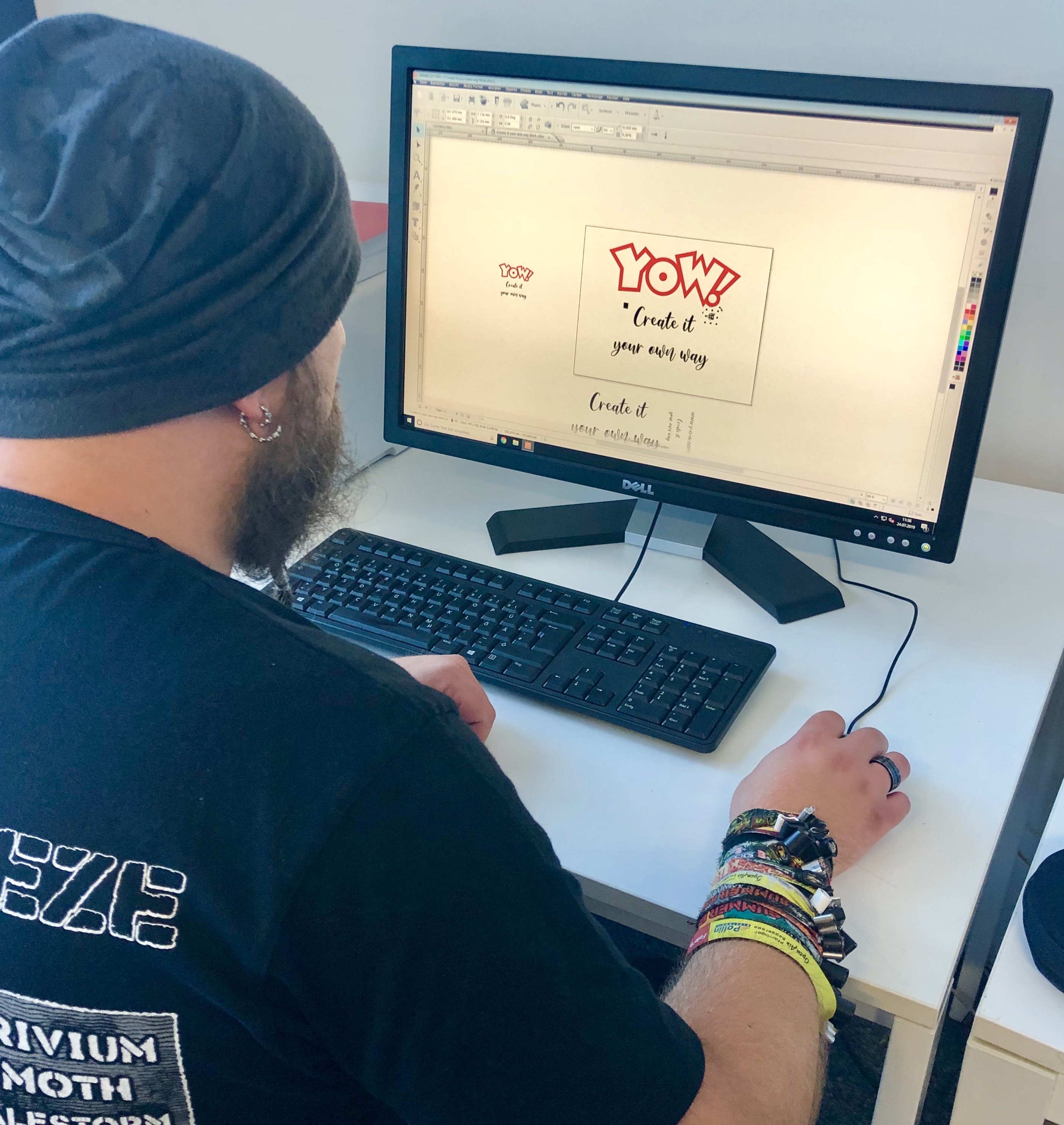 Mann gestaltet am Computer ein T-Shirt-Motiv mit rotem YOW!-Logo und Schriftzug Create it your own way in einem Grafikprogramm