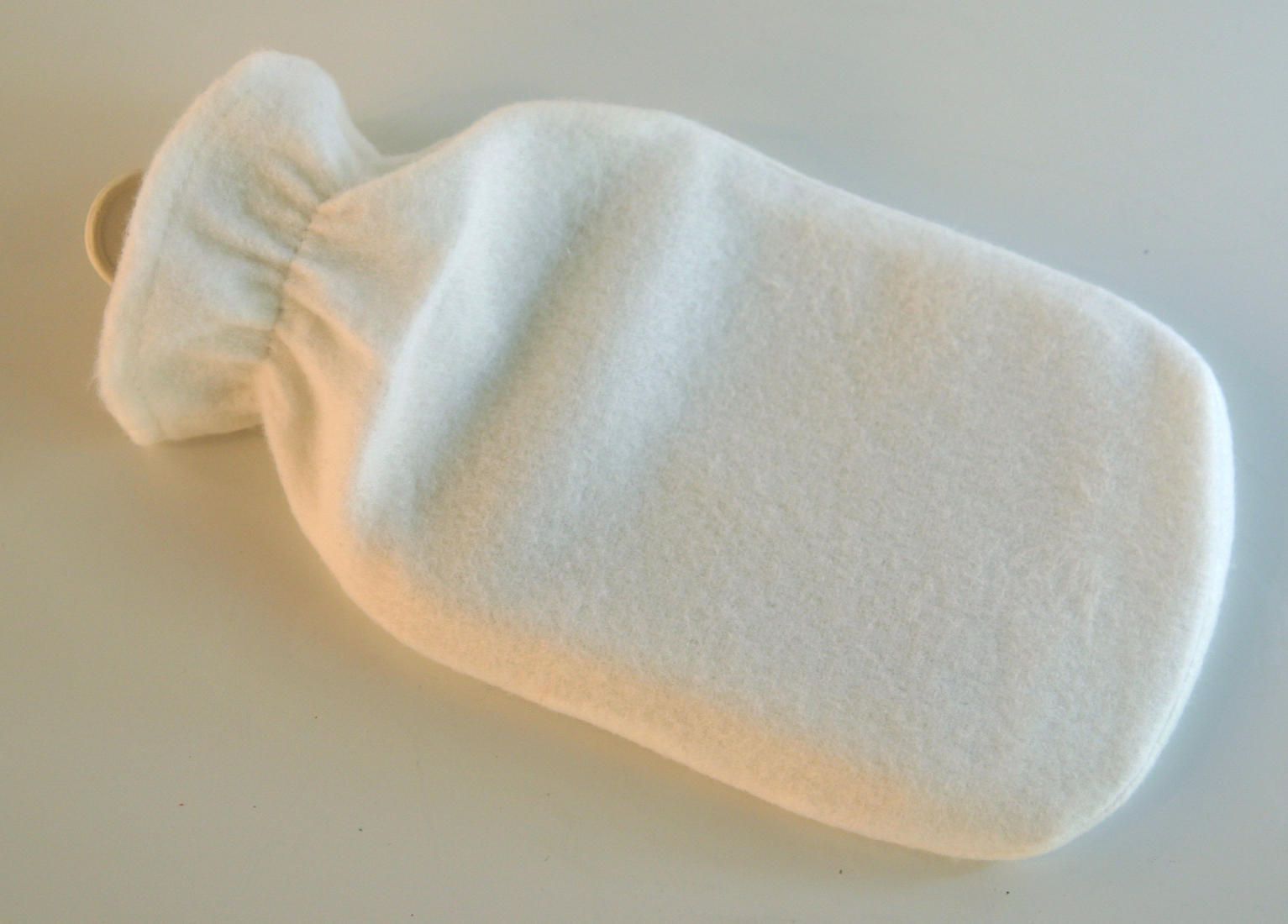 Wärmflasche mit weißem Fleece-Bezug ohne Motiv, Ausgangszustand vor dem Aufbringen des geplotteten Schriftzugs aus Flockfolie