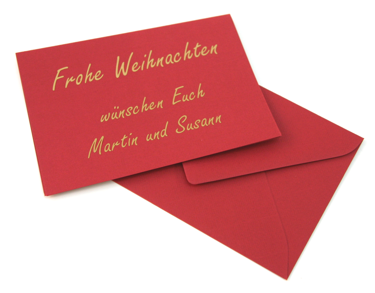 Rote Weihnachtskarte mit goldenem Folienschriftzug Frohe Weihnachten wünschen Euch Martin und Susann, daneben ein rotes Kuvert