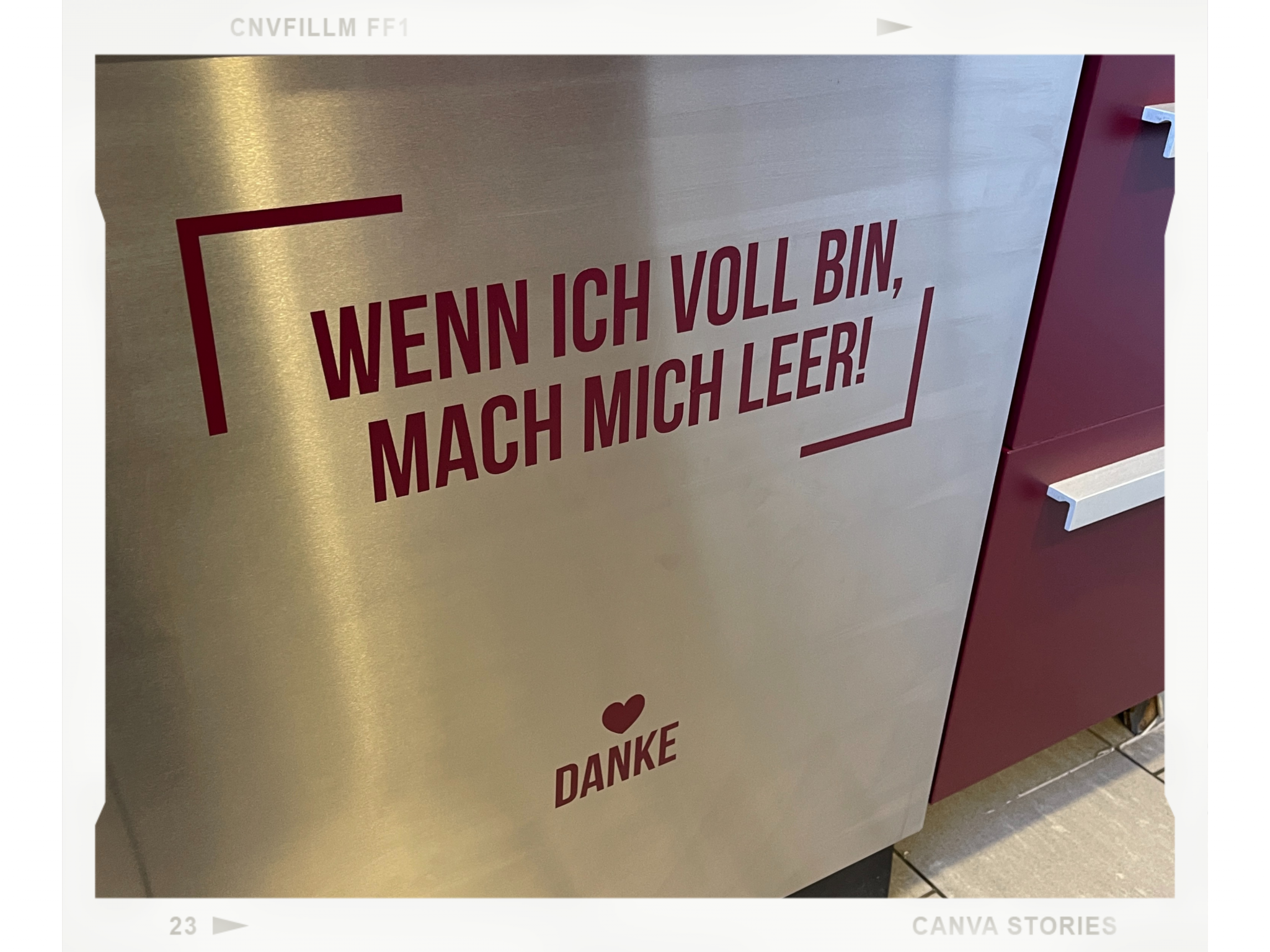 Edelstahlfront mit geplottetem Schriftzug Wenn ich voll bin, mach mich leer! und Herz mit Danke in Weinrot neben passenden Küchenschubladen
