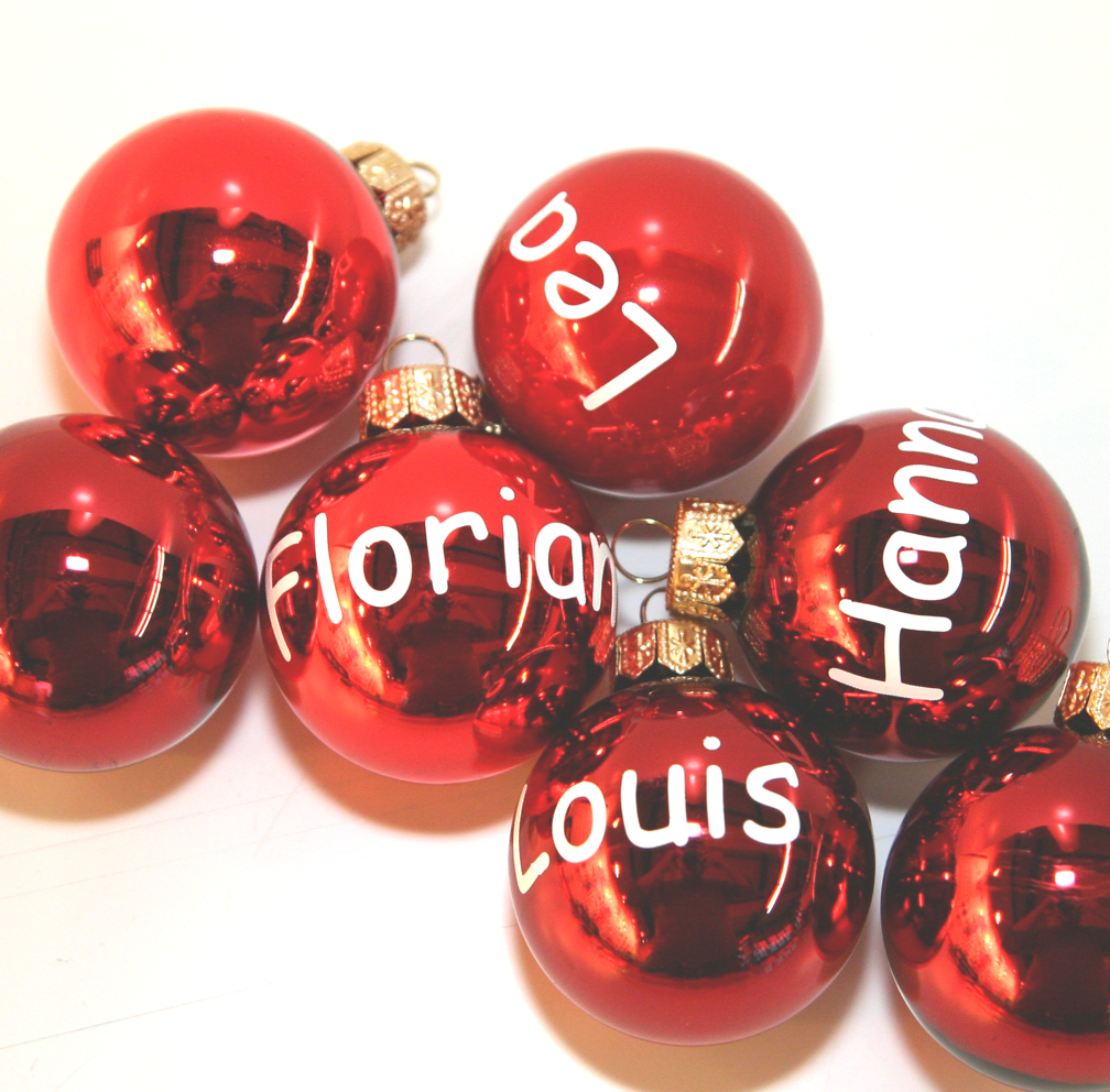 Rote Christbaumkugeln mit den Namen Leo, Florian, Hanna und Louis in weißer geplotteter Klebefolie