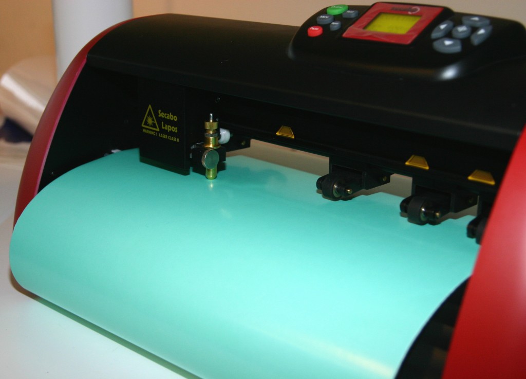 Schneideplotter von Secabo mit eingelegter türkisfarbener Maskierfolie, bereit zum Ausplotten der Gästenamen für die Teelichter