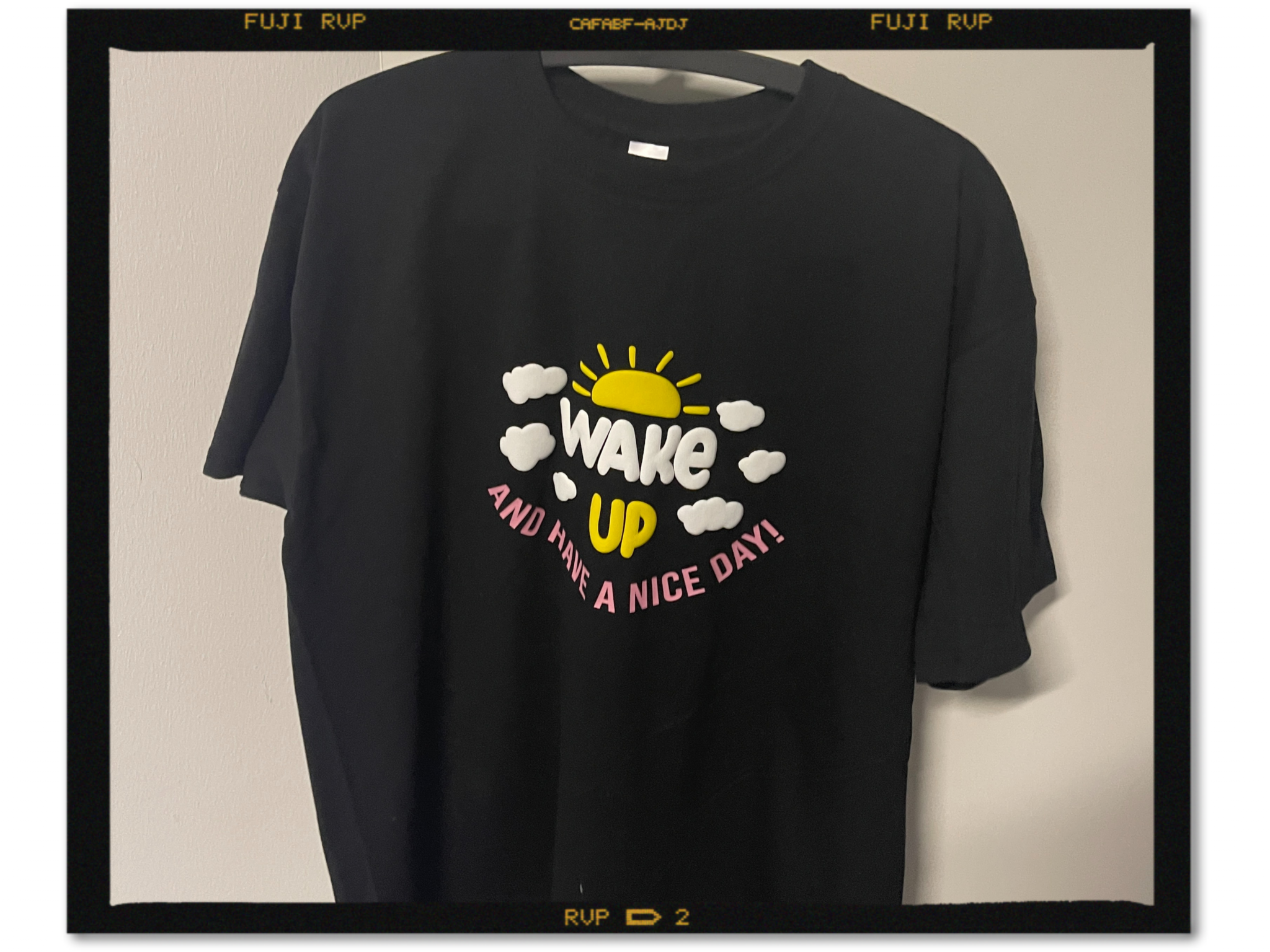 Schwarzes T-Shirt mit Wake up and have a nice day, Sonne und Wolken aus erhabener SEF Puff-Folie in Gelb und Weiß, Schrift in Candy Pink