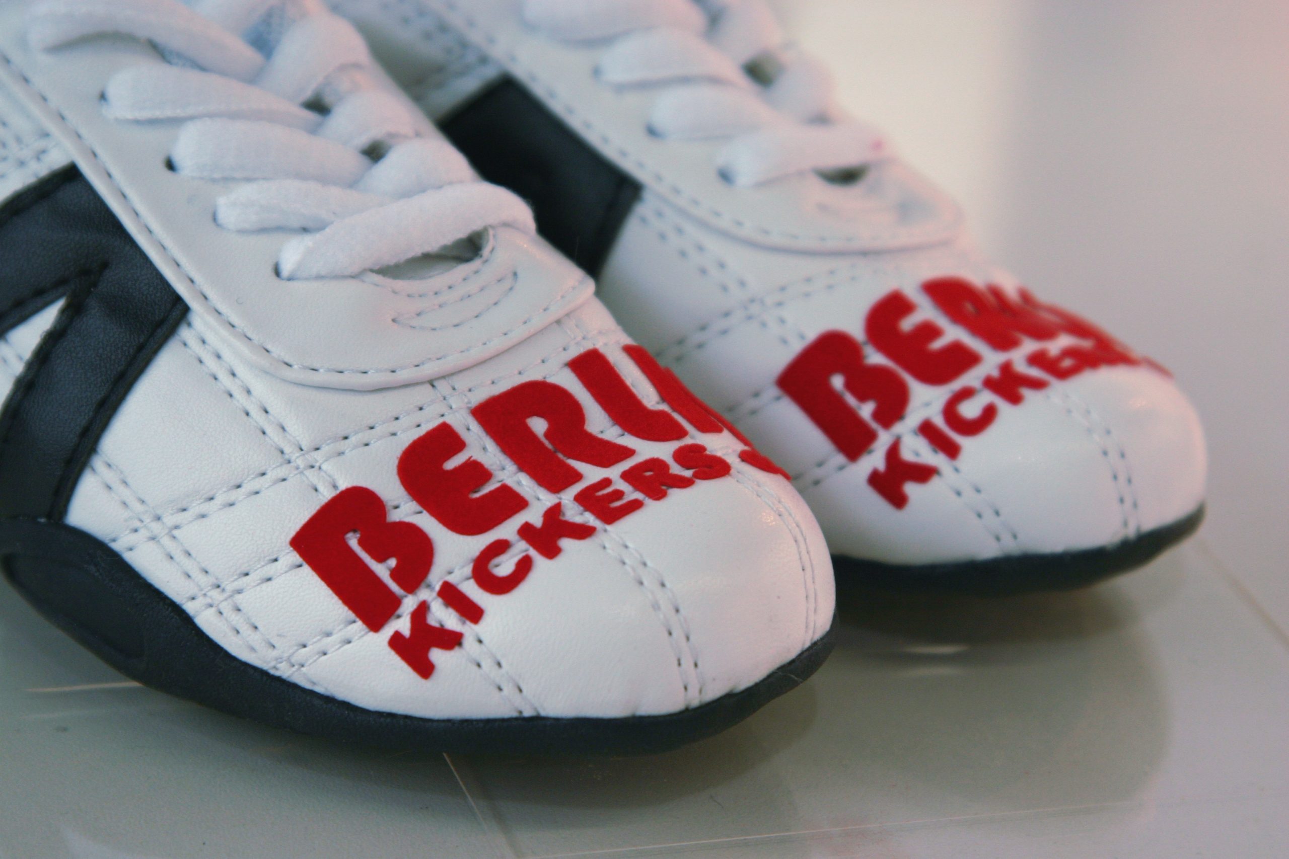 Weiße Sneaker mit rotem Schriftzug Berlin Kickers auf den Schuhspitzen, aufgebracht mit selbstklebender Flockfolie ohne Transferpresse