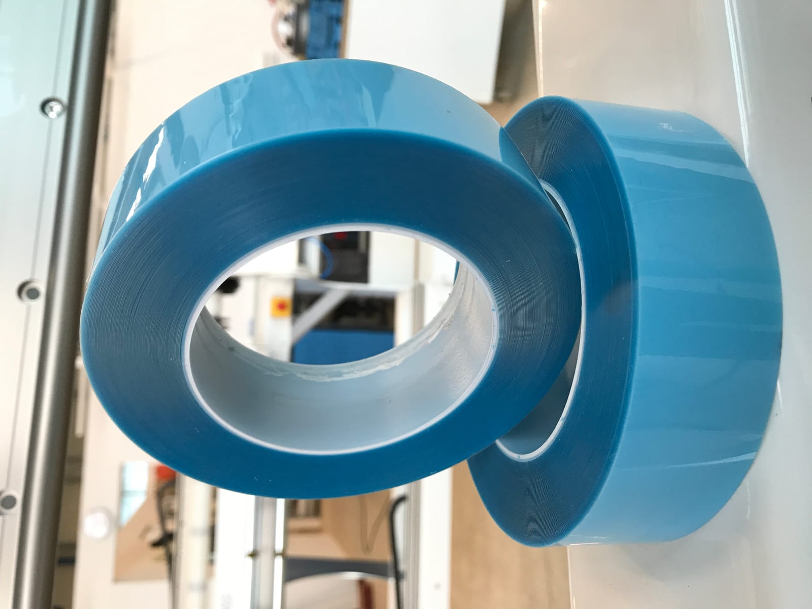 Zwei Rollen blaue Steinschlagschutzfolie mit sauberer, glatter Schnittkante ohne Ausfransen oder Kleberrückstände, abgestochen auf Rolle