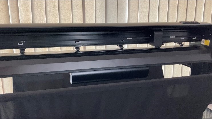 Schneideplotter Secabo T120 II mit Andruckrollen und Schneidkopf beim Ausplotten eines Motivs auf schwarzer Selbstklebefolie