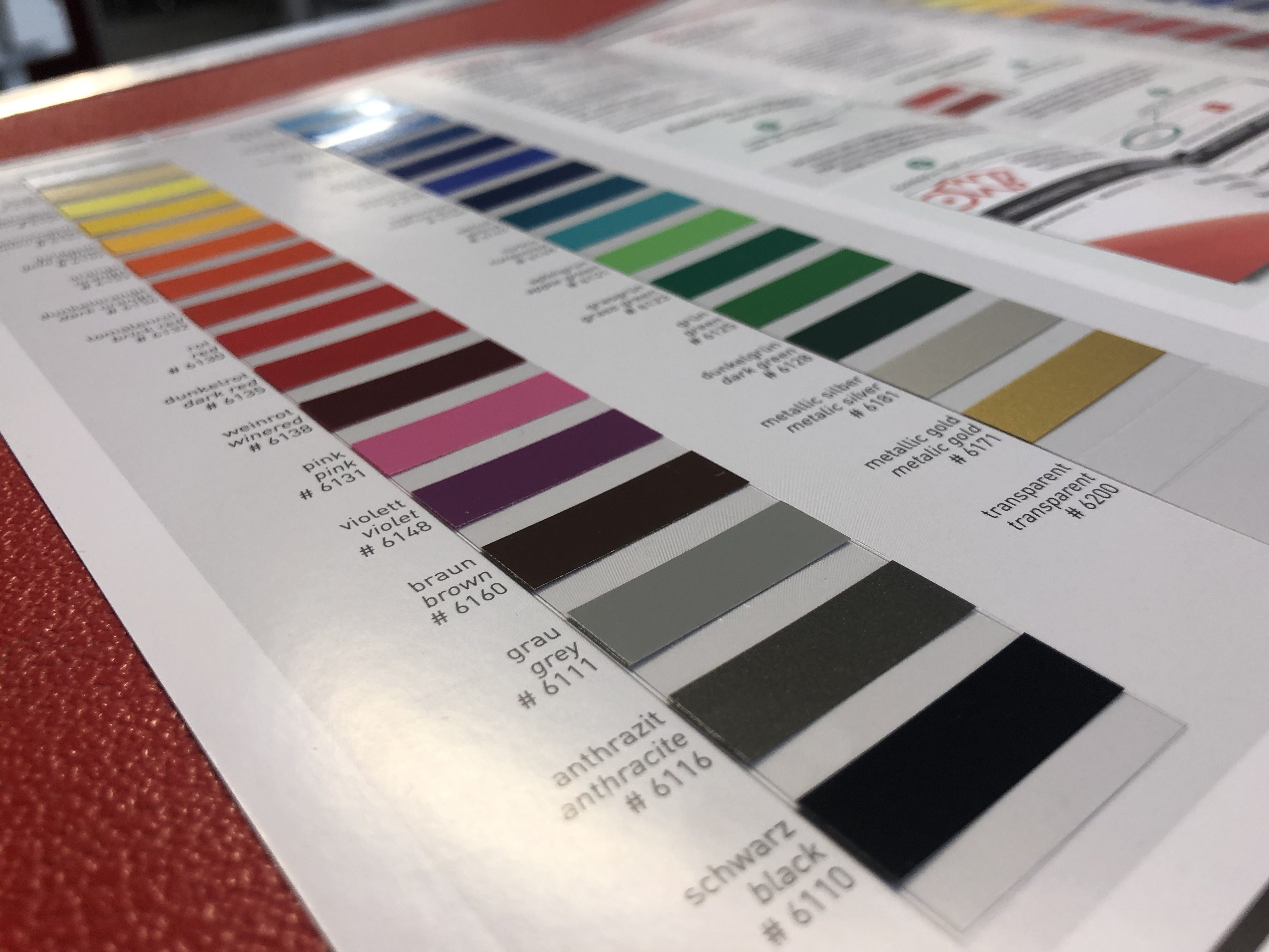 Farbkarte der YOW! Selbstklebefolien mit vielen Farbmustern von Gelb über Rot und Blau bis Schwarz, dazu Metallic Silber, Gold und Transparent