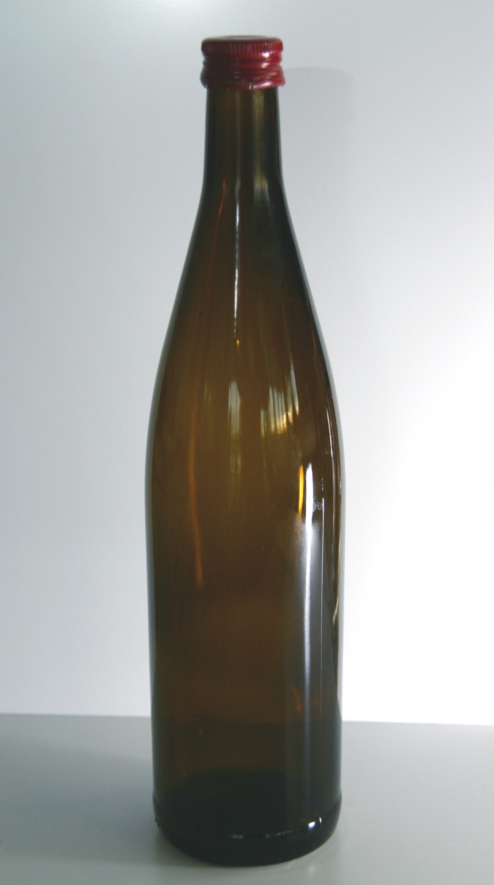 Braune Glasflasche mit rotem Schraubverschluss ohne Etikett, liegend vor weißem Hintergrund – Ausgangszustand vor dem Aufbringen des Etiketts