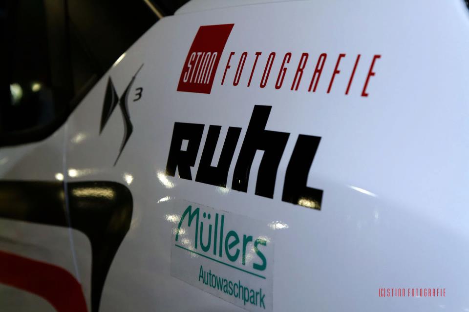 Weiße Karosserie des Rallye-Autos mit selbst geplotteten Sponsorlogos von Stinn Fotografie, Ruhl und Müllers Autowaschpark
