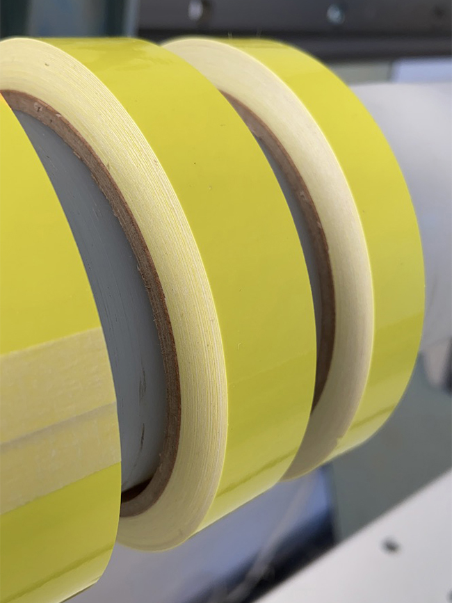 Des rouleaux de ruban adhésif jaune coupés sur des mandrins en carton, présentant des bords nets et lisses sans effilochage : le résultat de l'affûtage innovant de la lame