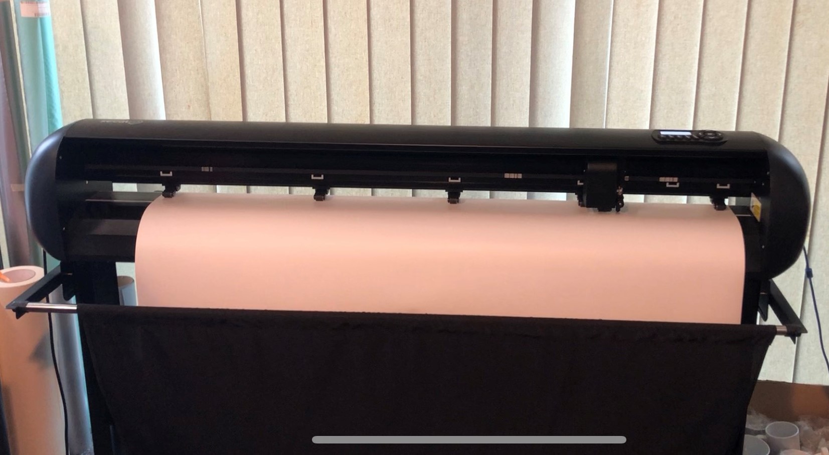 Schwarzer Secabo Schneideplotter auf Standfuß mit eingelegter Folienbahn, bereit zum Ausplotten von Motiven auf Milchglasfolie