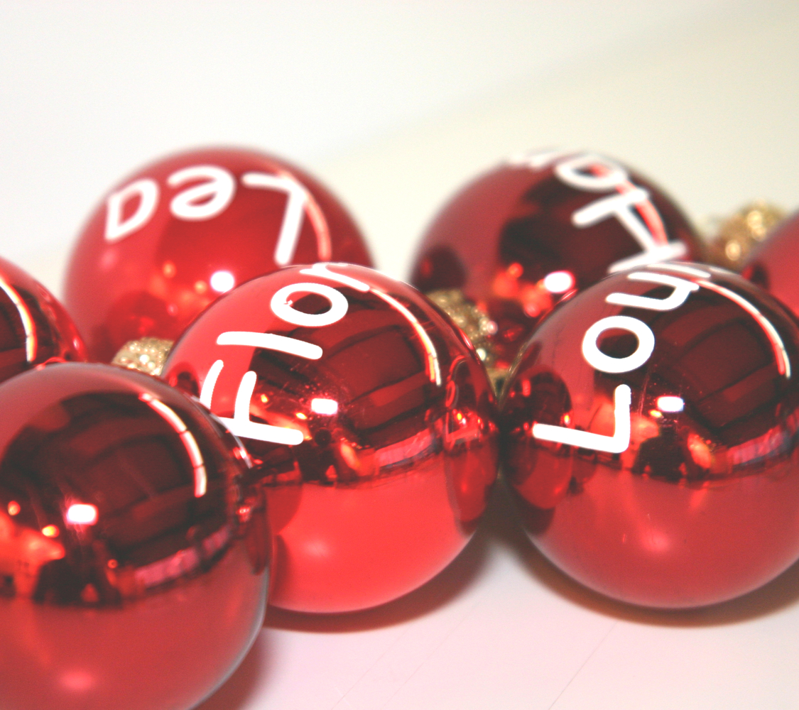 Glänzend rote Christbaumkugeln mit weißen Namen aus Plotterfolie, u. a. Lea und Louis, zur Kennzeichnung von Geschenken
