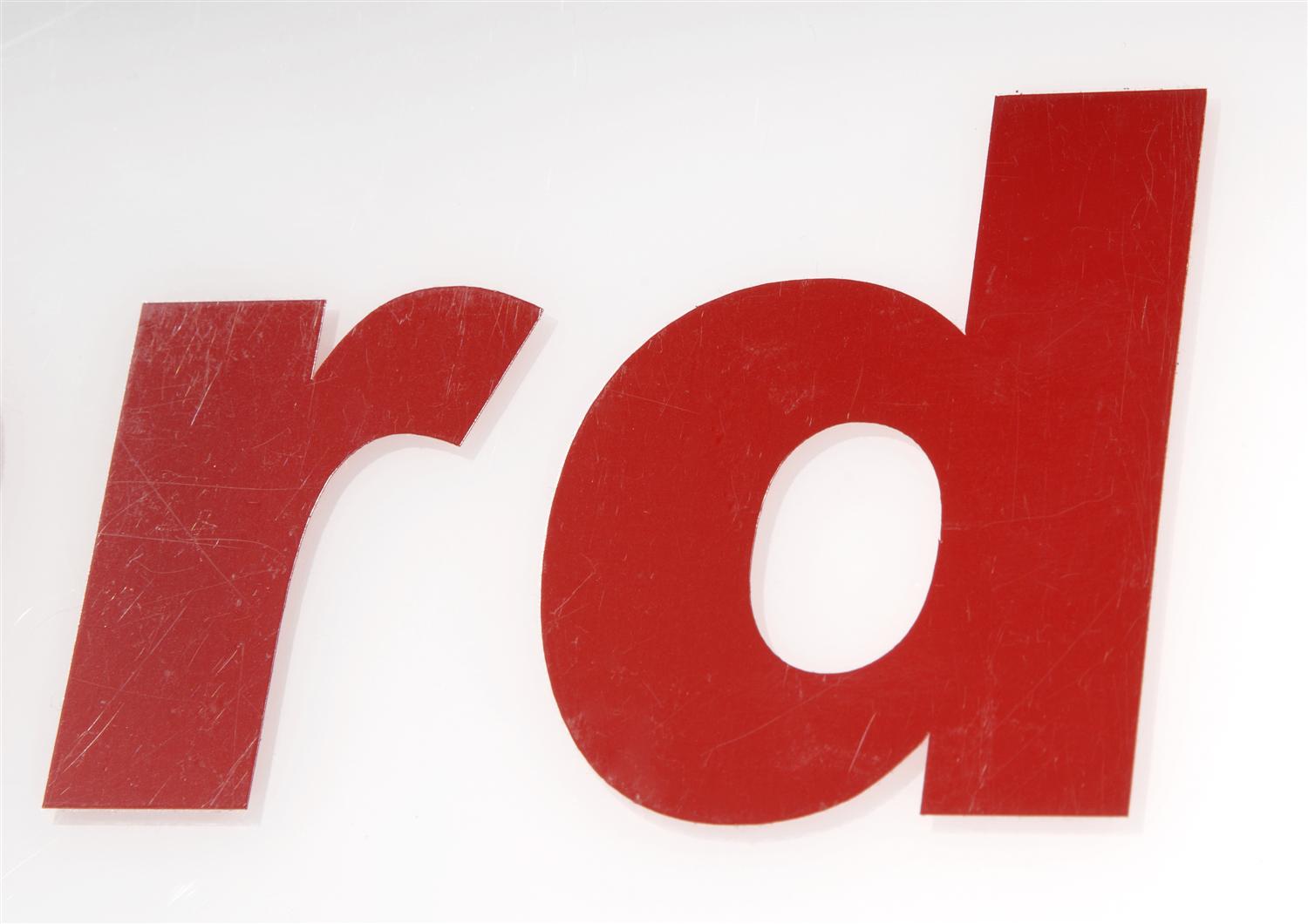 Rote, glänzende Folienbuchstaben r und d auf weißem Untergrund, Nahaufnahme mit feinen Kratzern als Beispiel für Ritrama standard glänzend