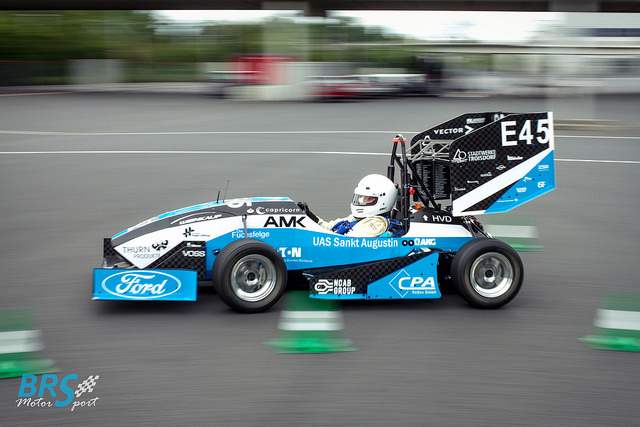 Rennwagen E45 von BRS Motorsport mit blau-weiß-schwarzer Folierung und Sponsorenlogos in voller Fahrt zwischen Pylonen