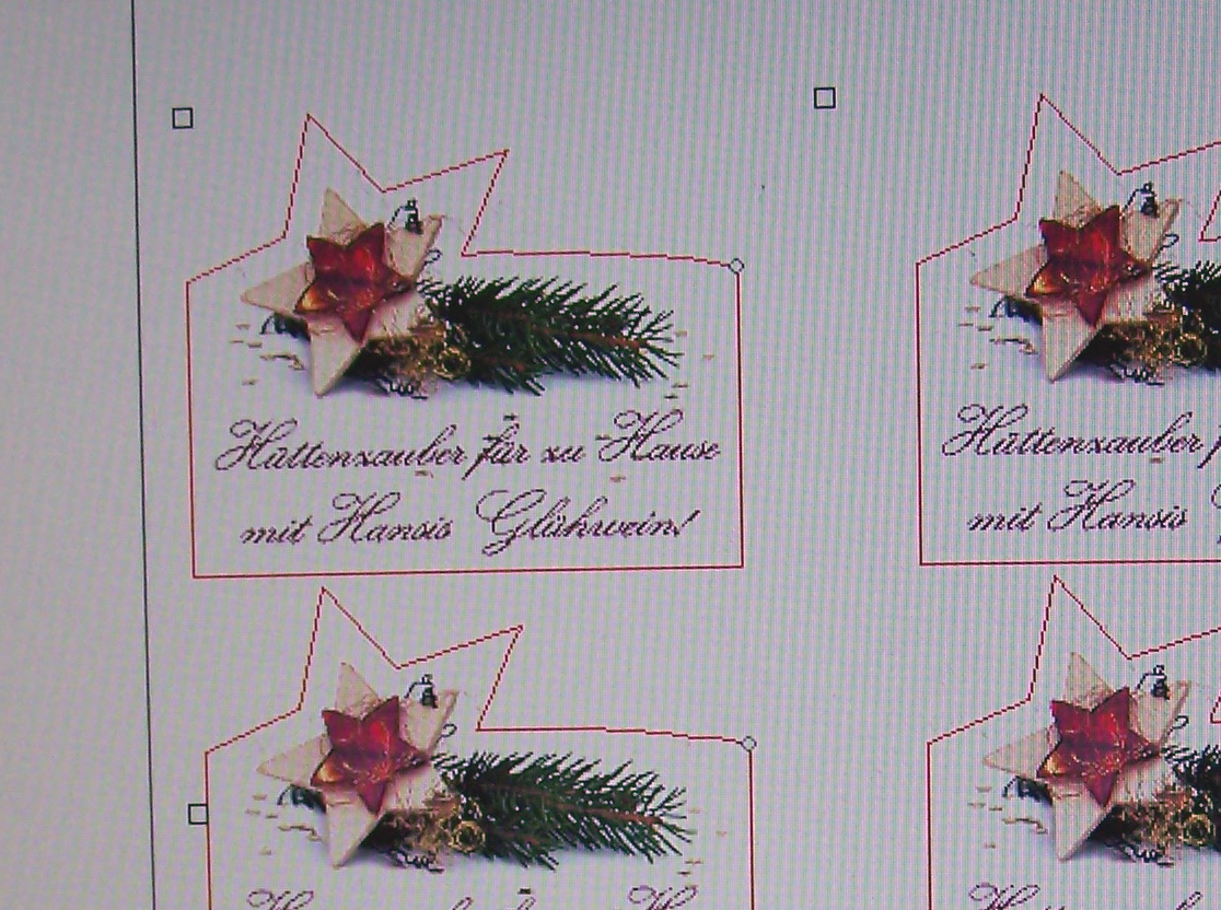 Etikettenentwurf am Bildschirm: Stern mit Tannenzweig, Text Hüttenzauber für zu Hause mit Hansis Glühwein, rote Schneidekontur und Passermarken