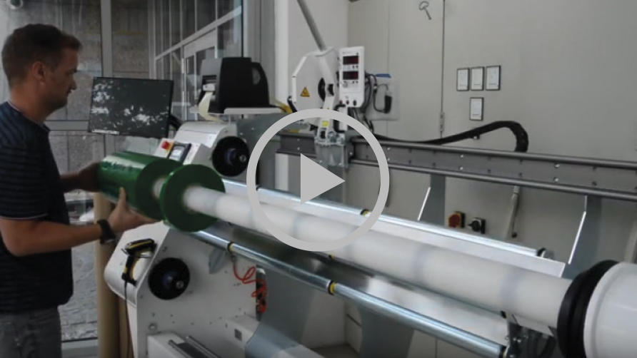 Aperçu vidéo : un employé retire des rouleaux de film protecteur vert coupés du mandrin d'une machine de transformation NEPATA équipée d'une tête de coupe