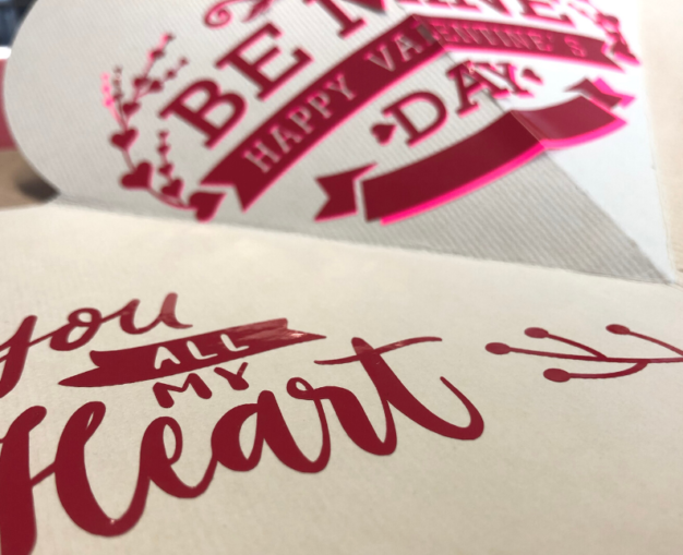 Mit dem Plotter geschnittene Valentinsmotive aus roter Folie auf hellem Karton, u. a. Be Mine – Happy Valentine's Day und You all my Heart