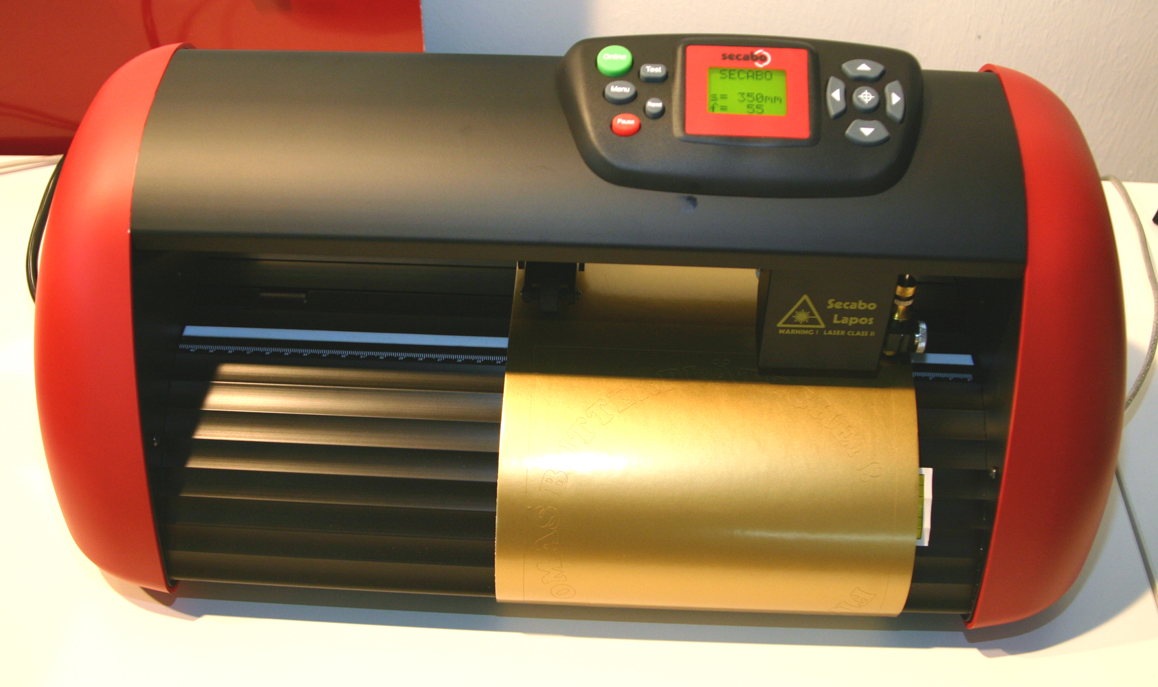 Rot-schwarzer Secabo-Schneideplotter mit goldener Selbstklebefolie, in die der Schriftzug Omas Butterplätzchen für die Dose geplottet ist