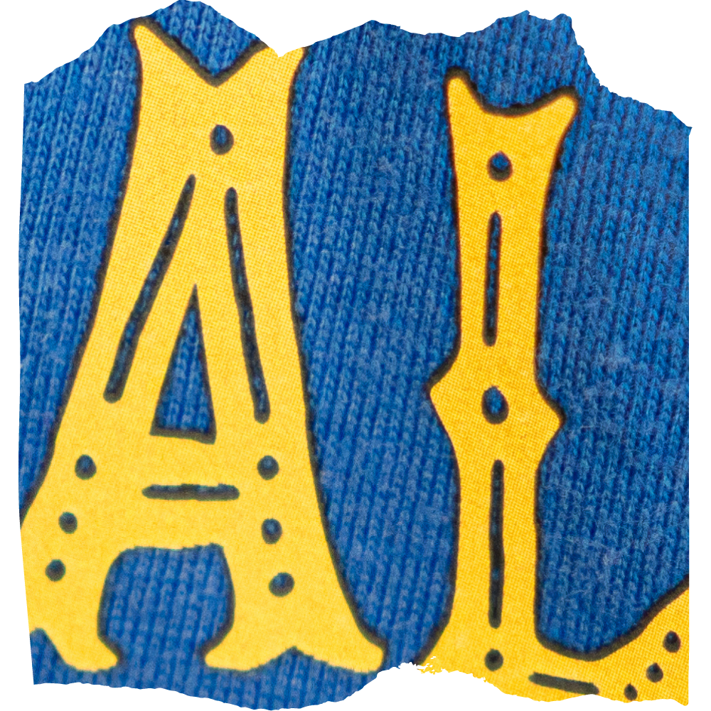Nahaufnahme: gelbe Zierbuchstaben A und L mit schwarzer Kontur als Ready Textiltransfer auf blauem Shirtstoff, Strickstruktur sichtbar