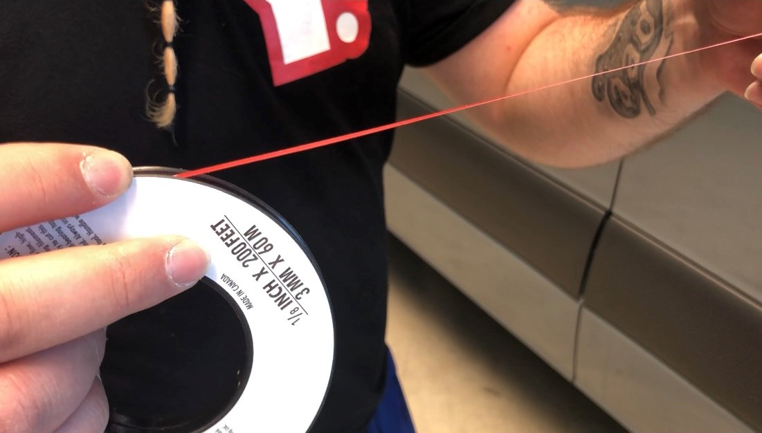 Rolle Schneidetape (3 mm x 60 m), rotes Tape wird zur Fahrzeugkante gezogen, um Folie ohne Cuttermesser sauber zu durchtrennen