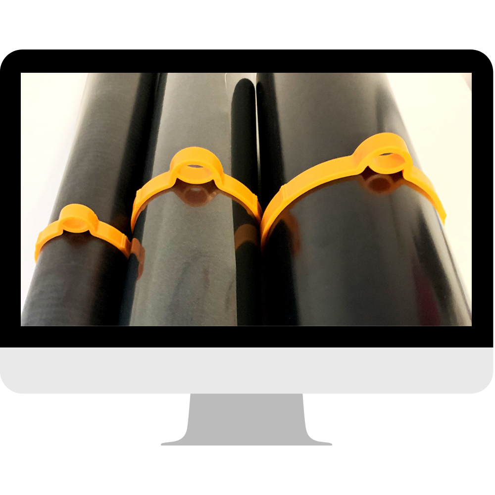 Drei orange Folienclipser in verschiedenen Größen an schwarzen Folienrollen verhindern das Aufrollen, gezeigt auf einem Monitor-Mockup