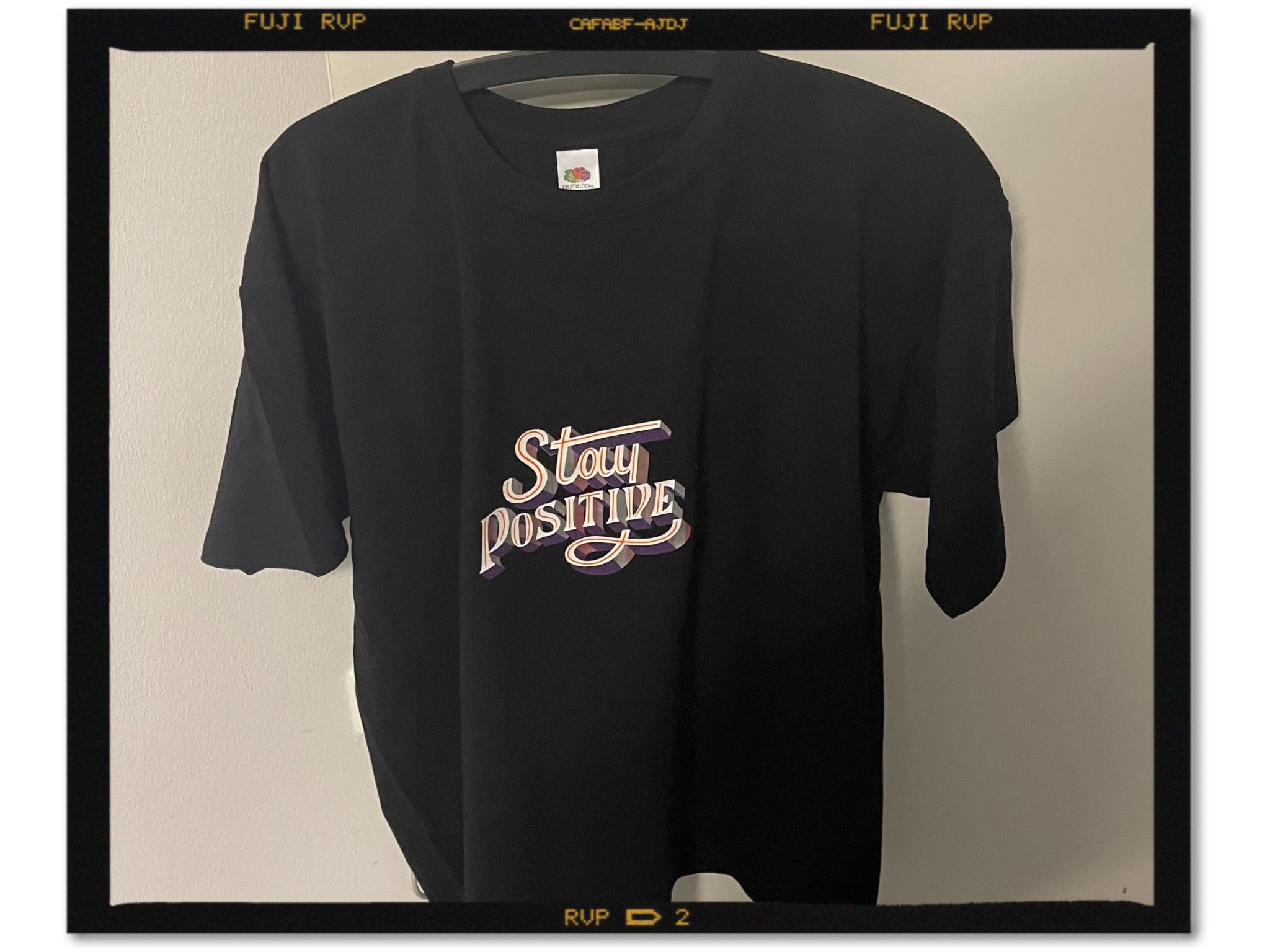 Schwarzes T-Shirt mit Schriftzug Stay Positive im 3D-Look aus weißer, oranger und dunkellila SEF Flex- und Flockfolie
