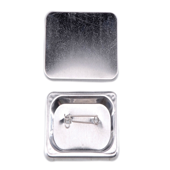 Bestandteile eines quadratischen Buttons (37 mm): silberne Vorderschale aus Metall und Rückwand mit Pin-Nadel