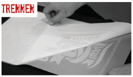 Hände ziehen nach dem Pressen die heiße A-Foil vom B-Paper ab, darunter ein weißes Motiv – Schritt 3 beim Tonertransferdruck: Bögen trennen