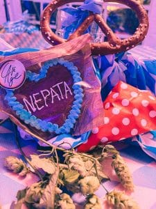 Lebkuchenherz mit Aufschrift NEPATA als Wiesn-Tischdeko mit Brezn, Hopfen und blau-weißem Rautenmuster beim Firmenfest 2021