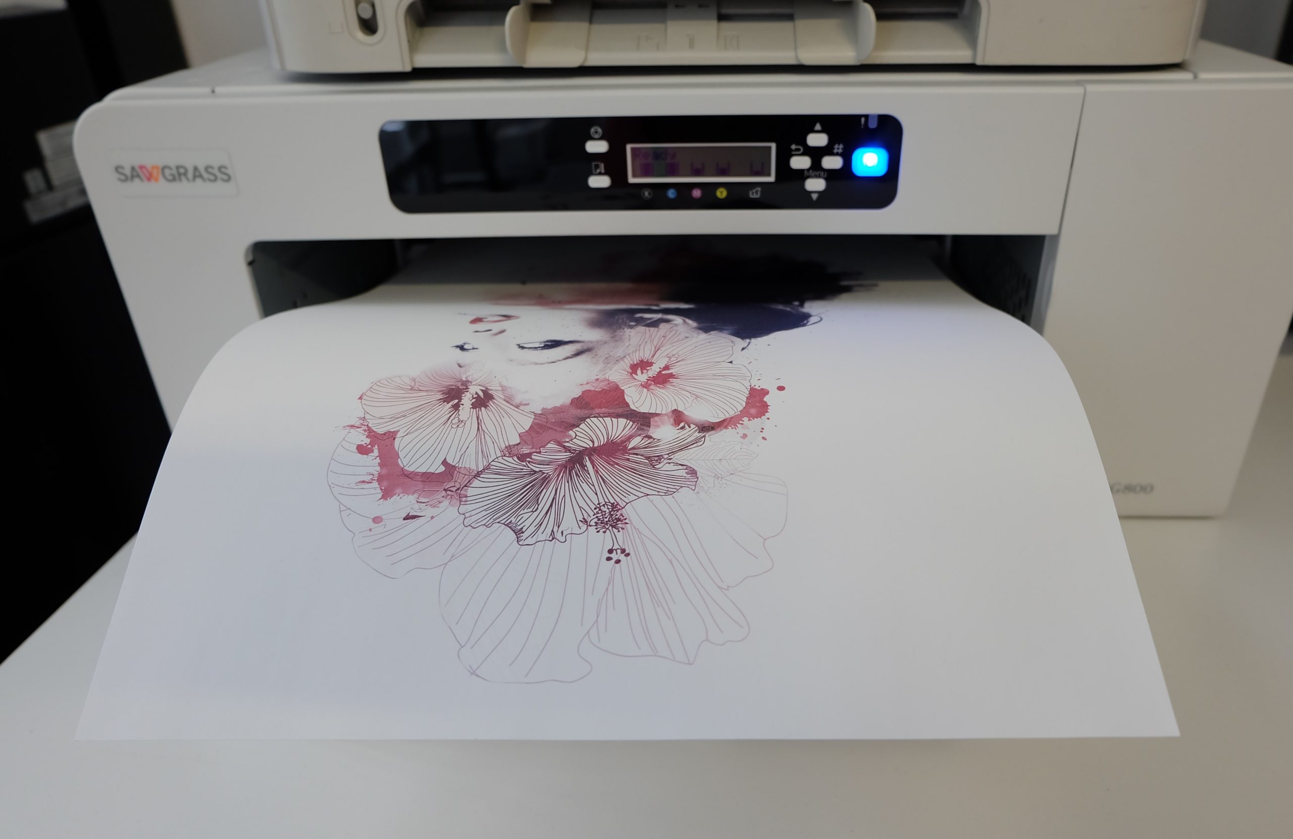 Sawgrass-Sublimationsdrucker gibt Transferpapier aus, bedruckt mit Frauengesicht und Hibiskusblüten in Rot- und Violetttönen