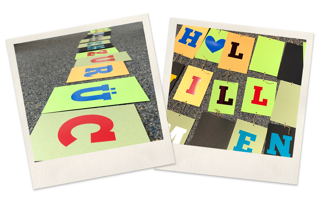 Bunte Pappkarten mit geplotteten Folienbuchstaben, links in einer Reihe zu ZURÜCK gelegt, rechts mit Schnur zur Girlande verbunden