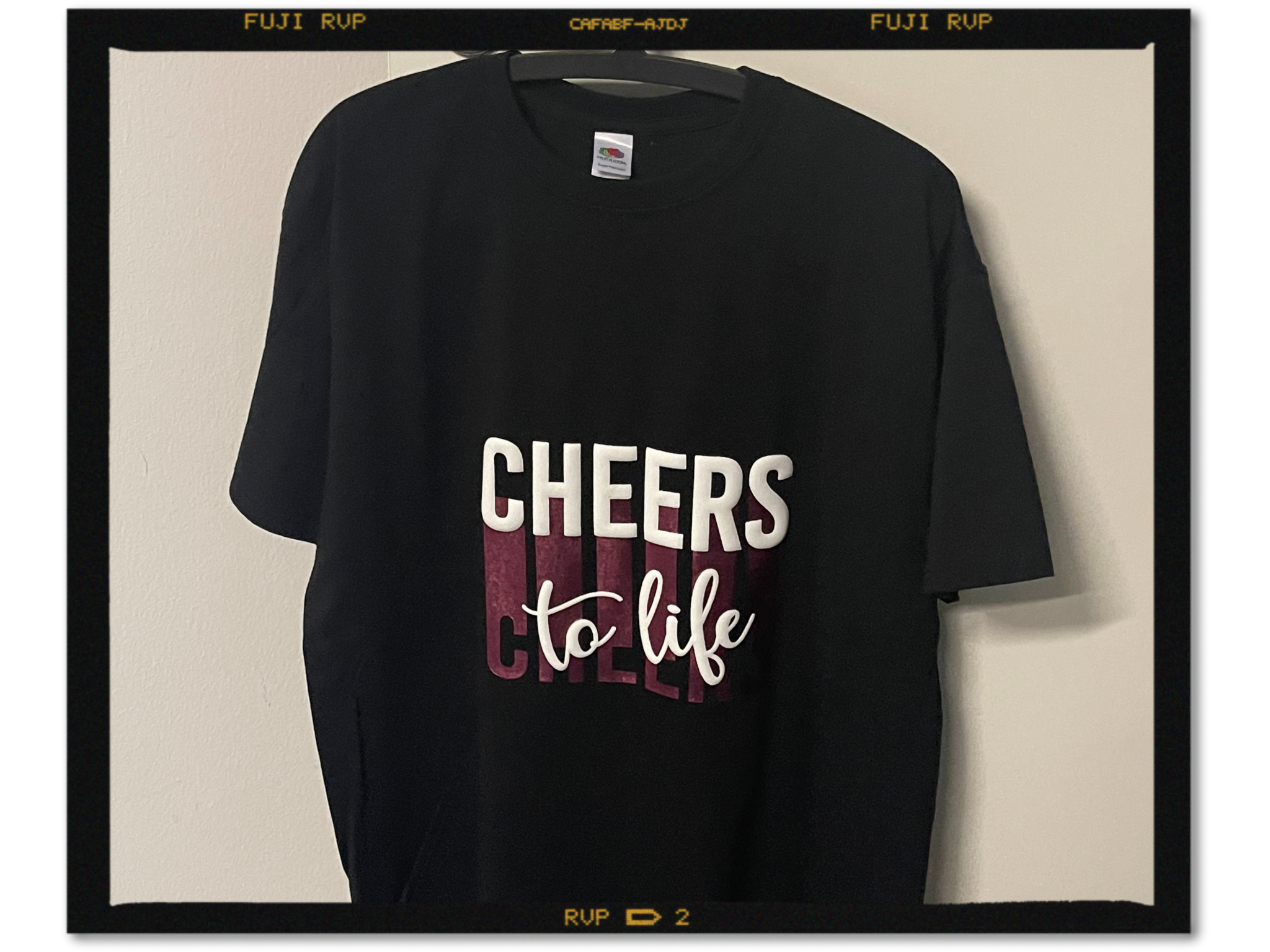Schwarzes T-Shirt mit Schriftzug Cheers to life in erhabener weißer Puff-Flexfolie über Metallic-Flexfolie in Candy Pink