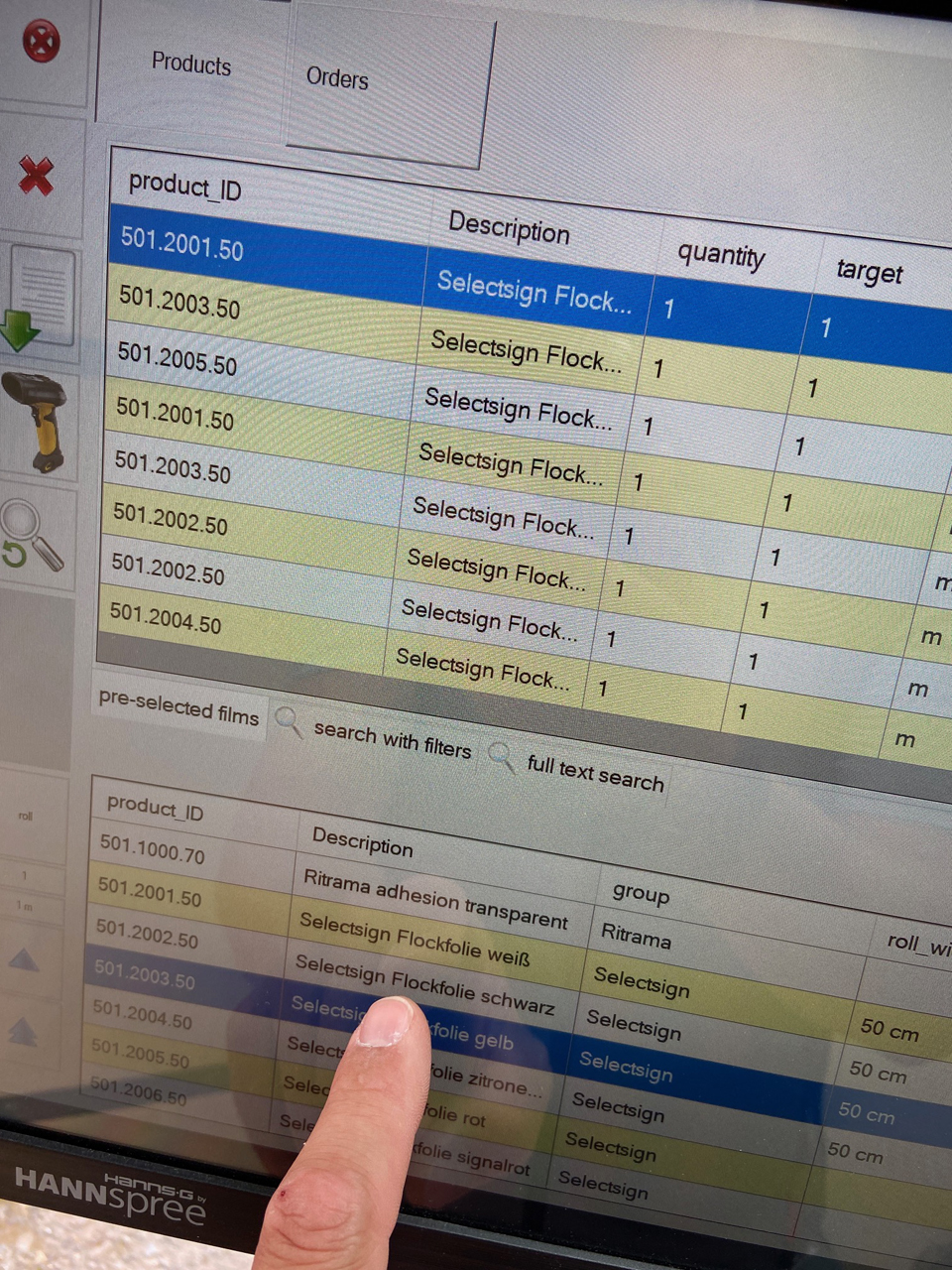 Sur l'écran tactile, Finger sélectionne un film flock Selectsign dans la liste des produits ConvertPlus2 ; au-dessus, la file d'attente de production
