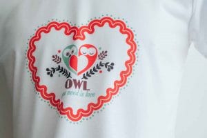 Weißes T-Shirt mit rotem Herzmotiv, zwei Eulen und Schriftzug OWL: Beispiel für bedruckte Ware, die die Firma trotz Pandemie weiter versendet