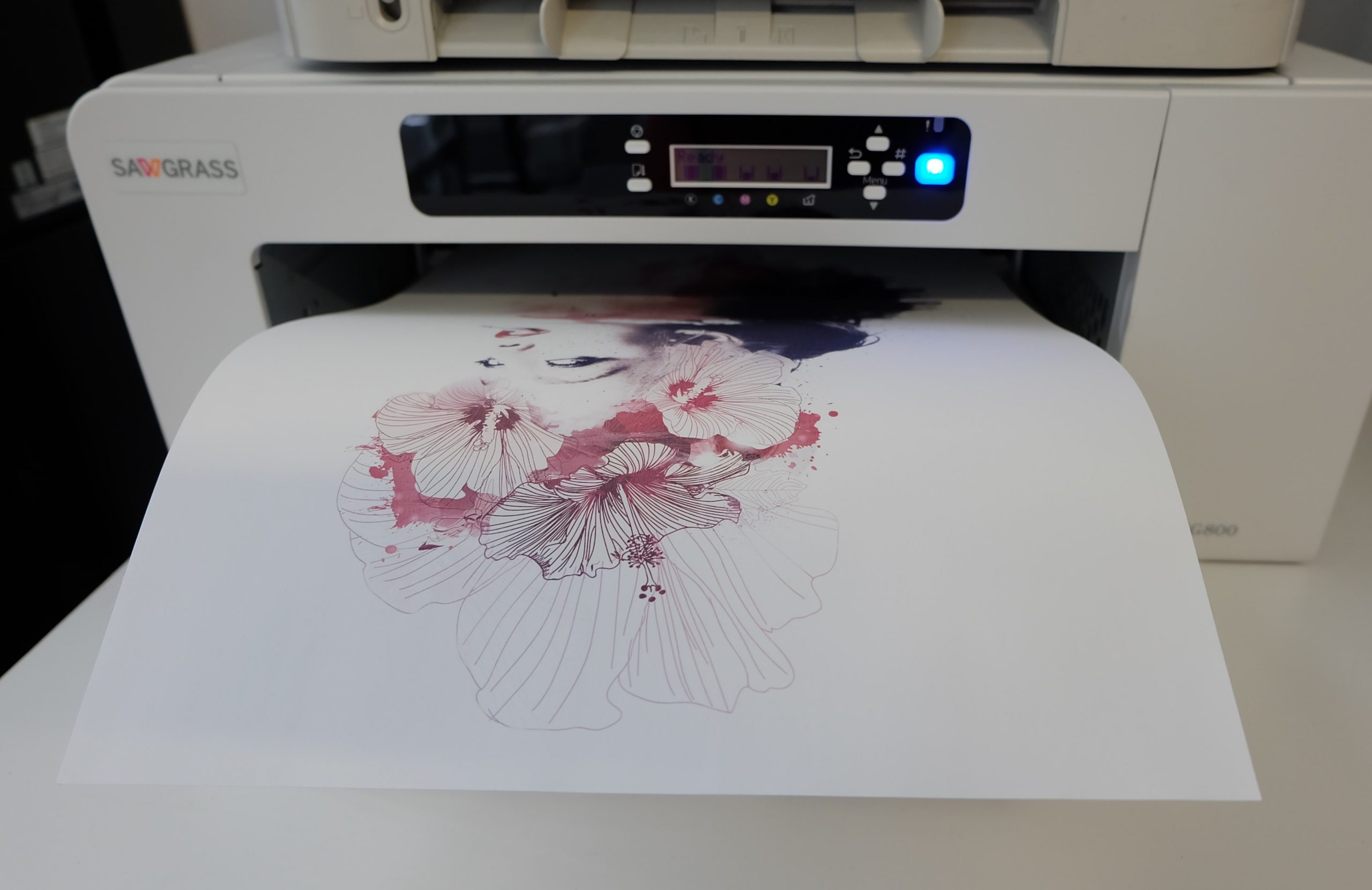Sawgrass Virtuoso SG800 gibt Sublimationspapier aus, bedruckt mit Frauenporträt und Hibiskusblüten in Rot- und Violetttönen