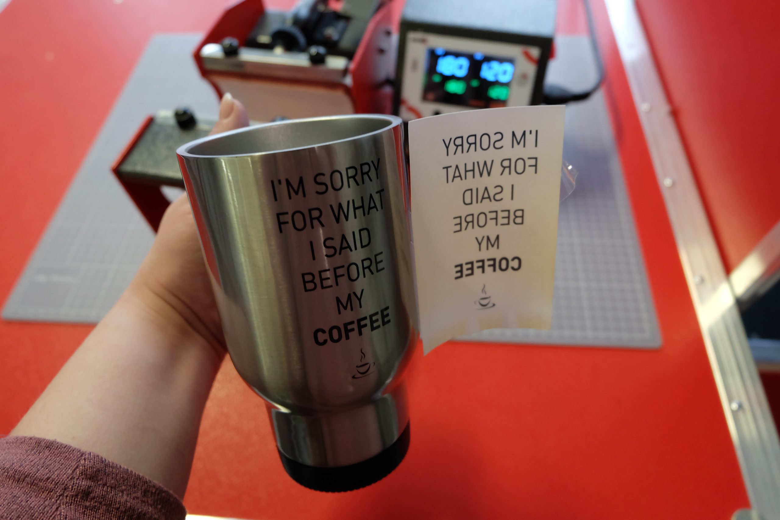 Edelstahl-Thermobecher mit Aufdruck I'm sorry for what I said before my coffee, Transferpapier mit Spiegeldruck wird abgezogen, vor Tassenpresse