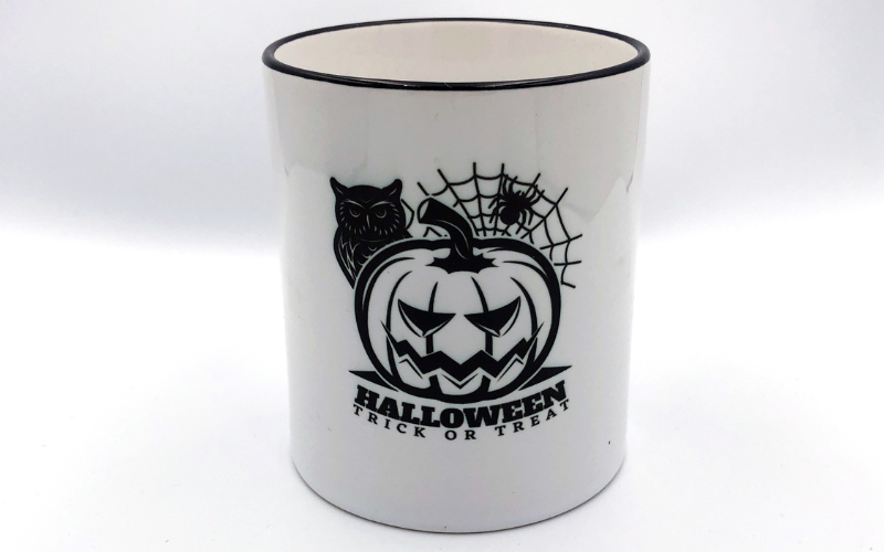 Weiße Tasse mit sublimiertem Halloween-Motiv: Kürbis, Eule, Spinnennetz und Schriftzug Trick or Treat